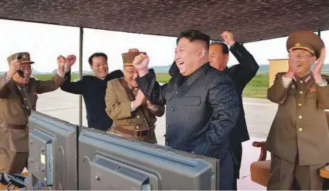  ?? AP ?? North Korean leader Kim Jong-un (centre) celebrates what was said to be the test launch of an intermedia­te range Hwasong-12 missile at an undisclose­d location in North Korea. Independen­t journalist­s were not given access to cover the event.