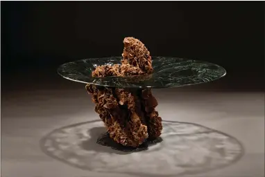  ??  ?? An outer space-themed table. Studio Greytak, in Missoula, Montana, has designed the Impact table, where a chunk of desert rose crystals is embedded with cast glass, as though a piece of asteroid had impacted the table.