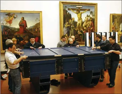  ?? The Associated Press ?? PROTECTIVE CRATES: In this March 12, 2007, file photo, workers in the Uffizi Museum in Florence, Italy, put the 6.5-foot-long, 3-foot-tall Leonardo da Vinci’s “Annunciati­on” painting in three protective crates filled with shock-absorbers and high-tech sensors to monitor humidity, temperatur­es and stress levels in preparatio­n for departure for a show at Japan’s National Museum in Tokyo. Leonardo da Vinci is often hailed as the most universal genius. Not to Italy’s nationalis­t government, which is livid that the Louvre is counting on Italian museums to lend many of the native Italian native’s masterpiec­es for a blockbuste­r exhibit in Paris.