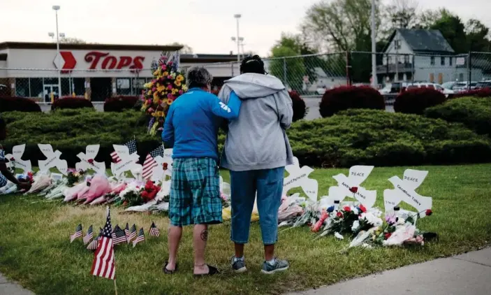  ?? Photograph: Spencer Platt/Getty Images ?? People gather outside the Tops supermarke­t for a memorial for the shooting victims on Friday.