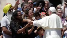  ??  ?? Pope Francis meets members of “Share the Journey”, an associatio­n which helps refugees, in St. Peter’s Square at the Vatican, during his weekly general audience, on Wednesday. aP PhoTo/alessandra TaranTIno