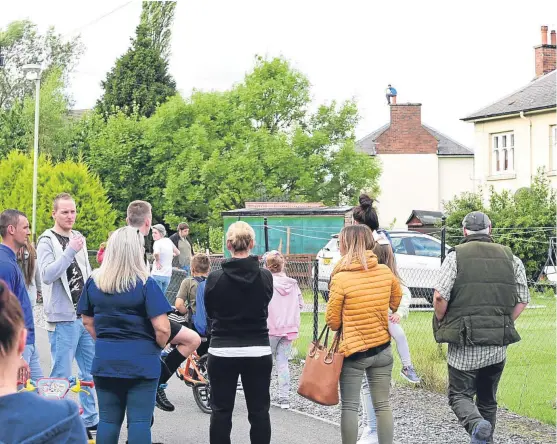  ??  ?? Crowds gathered during the stand-off, which began yesterday around 9am, to see a man sitting on a chimney stack.