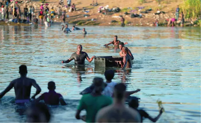  ?? EFE ?? Migrantes haitianos cruzan el río Grande, entre Estados Unidos y México, para establecer­se en el campamento improvisad­o en Ciudad Acuña, ayer
