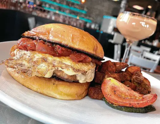  ?? Photos by Mike Sutter / Staff ?? A breakfast sandwich at Full Belly Cafe and Bar includes a fried egg, housemade sausage, cheese and tomato chutney, built on a brioche bun baked in-house.