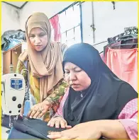  ?? — Gambar Bernama ?? KONGSI ILMU: Siti Norhayati (kiri) memberi tunjuk ajar kepada pekerjanya di Kubang Kerian kelmarin.