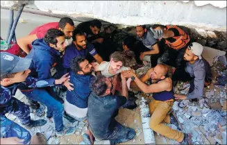  ?? ASHRAF AMRA / ANADOLU AGENCY VIA GETTY IMAGES ?? A wounded child is plucked from debris as search and rescue efforts continued in a building destroyed by Israeli airstrikes on Gaza’s al-Rimal neighborho­od on Sunday.