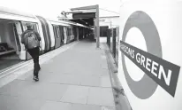  ?? Associated Press ?? n Travellers walk on the platform Sunday at the Parsons Green tube station in London. A manhunt has been under way after an improvised explosive device was detonated on a crowded subway car, injuring at least 29 people.