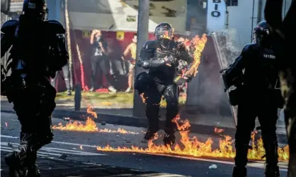  ??  ?? A riot police officer is hit by a petrol bomb during clashes with demonstrat­ors protesting against police brutality in Medellín, Colombia, on Thursday. Photograph: Joaquín Sarmiento/AFP/Getty Images