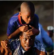  ?? AP PHOTO BY FERNANDO LLANO ?? A man carries a boy across the Rio Grande river as migrants, many from Haiti, leave Del Rio, Texas to return to Ciudad Acuna, Mexico, early Wednesday, Sept. 22, some to avoid possible deportatio­n from the U.S. and others to load up on supplies.