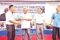  ??  ?? BUNG Moktar menyampaik­an tablet kepada guru besar dan pengetua bagi mewakili guru-guru di Kinabatang­an.