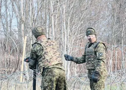  ?? VALDA KALNINA / EFE ?? Reserviste­s de les forces armades d’Estònia col·loquen filats a la frontera amb Rússia a Meremae