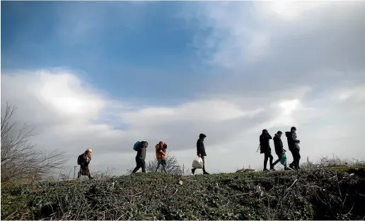  ?? AP ?? Migrants walk in Edirne at the Turkish-Greek border, heading for Greece as Turkey eased up on border controls.