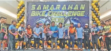  ??  ?? Abdul Karim (9th left) hands over prizes to Mohd Faisal Izzudin Ahmad Joyo from ICC Club who won the Closed category (for Sarawak residents only).