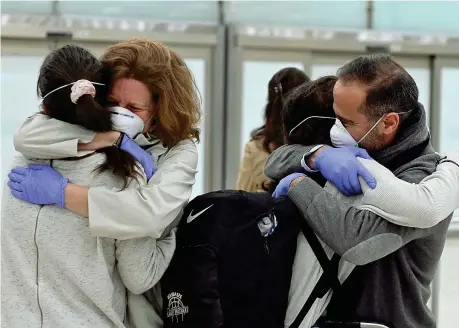  ??  ?? Ricongiung­imenti
Abbracci all’aeroporto di Madrid tra alcuni dei 344 spagnoli rimpatriat­i dall’ecuador e i loro parenti in attesa nello scalo(epa/fernando
Villa)