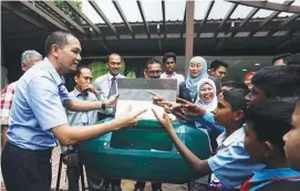  ?? ZULFADHLI ZAKI/ THESUN ?? ... Subang Jaya Municipal Council deputy president Zulkarnain Che Ali (left) telling schoolchil­dren about organic waste composting during a visit to the Biomass Centre in Puchong, Selangor, yesterday. The centre conducts large-scale compositin­g of...