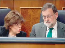  ?? — AFP ?? Deputy Prime Minister Soraya Saenz de Santamaria (L) talks to Prime Minister Mariano Rajoy during a debate on a no-confidence motion at the Lower House of Parliament on Thursday.