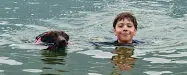  ??  ?? A nuoto Lorenzo Corti, 11 anni, con il suo cane Red
