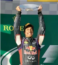  ??  ?? Red Bull driver Daniel Ricciardo of Australia holds up his trophy in celebratio­n after finishing second in the Australian GP. —