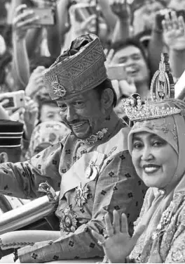  ?? —AFP ?? ROYAL CHARIOT Brunei’s Sultan Hassanal Bolkiah and Queen Saleha greet well-wishers from a royal chariot during a procession to mark his 50th year on the throne.