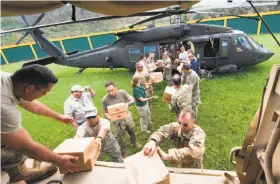  ?? U.S. Department of Defense ?? Puerto Rico National Guard soldiers unload a helicopter carrying relief supplies in Jayuya. Most residents have no power or drinking water.