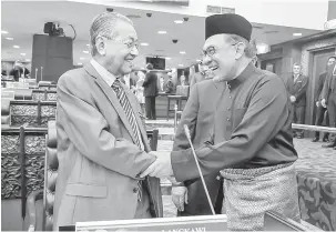  ?? — Gambar Bernama ?? MESRA: Dr Mahathir (kiri) bersalaman bersama Anwar sebelum mengangkat sumpah sebagai Anggota Dewan Rakyat pada Mesyuarat Kedua Penggal Pertama Majlis Parlimen ke-14 di Bangunan Parlimen di Kuala Lumpur semalam.