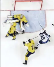  ?? MARK HUMPHREY — THE ASSOCIATED PRESS ?? Winnipeg’s Paul Stastny (25) scores against Nashville goalie Pekka Rinne (35) during the second period in Game 1 Friday in Nashville, Tenn. Predators’ Nick Bonino (13) and P.K. Subban (76) also defend.