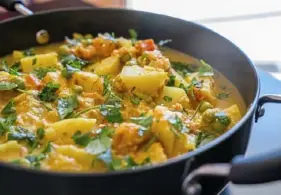  ?? Andrew Rush/Post-Gazette photos ?? Fragrant with fennel seeds, cinnamon and curry leaves, potatoes and peas are cooked in an almond-coconut sauce for this korma.