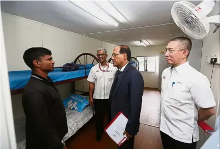  ??  ?? Good living conditions: Sayedul (second right) talking to a Bangladesh­i worker while Najmuddin (right) and MRT Corp director of standard and compliance Syed Mahdhar Syed Hussain (second left) look on during a tour.