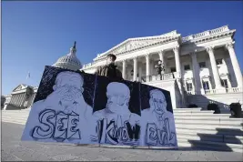  ?? STEVE HELBER — THE ASSOCIATED PRESS ?? Stephen Parlato, of Bolder, Colo., displays his artwork depicting, “the evil Republican senatorial judges”, as he demonstrat­es outside the U.S. Capitol Wednesday in Washington.