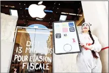  ??  ?? This file photo shows an activist from the Associatio­n for the Taxation of financial Transactio­ns and Citizen’s Action (ATTAC) posing next to an inscriptio­n which translate as ‘(Apple) owes 13 billion (euros) due to tax evasion’ in front of an Apple...