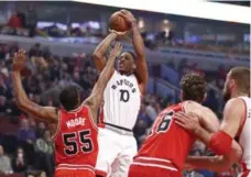  ?? CHARLES REX ARBOGAST/THE ASSOCIATED PRESS ?? Raptors guard DeMar DeRozan shoots over Bulls guard E’Twaun Moore in Chicago on Friday night. DeRozan scored 22, but the Raptors lost 116-106.