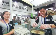  ?? PROVIDED TO CHINA DAILY ?? Attendants cook instant noodles at the COFCO booth during a food safety technology exhibition in Beijing.