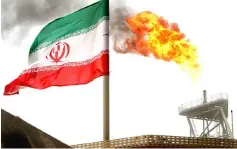  ??  ?? A gas flare on an oil production platform in the Soroush oil fields is seen alongside an Iranian flag in the Persian Gulf. — Reuters photo