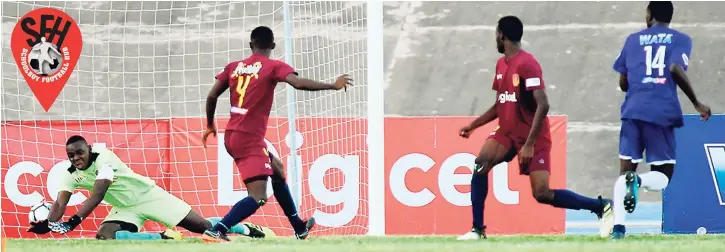  ??  ?? Shaquille Smith (right) of Kingston college scores in the Manning Cup semi-final against St Andrew Technical High School at the National Stadium yesterday.