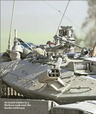  ??  ?? An Israeli soldier in a Merkava tank near the border with Gaza