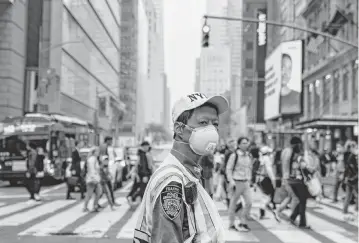  ?? DAVID DEE DELGADO Getty Images/tns, file ?? A traffic officer wears an N95 mask in Times Square amid a smoky haze from wildfires in Canada on June 7, 2023, in New York. Officials were accused of waiting too long to warn about the dangers from the smoke.