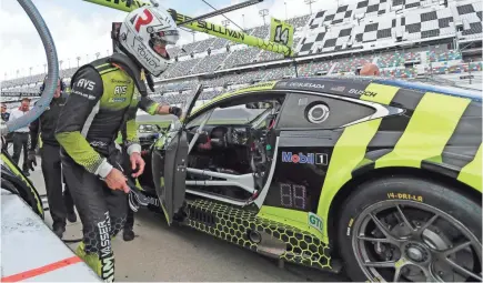  ?? JOHN RAOUX/AP ?? Kyle Busch prepares to climb into his car Friday to drive during testing for the upcoming Rolex 24 hour auto race at Daytona Internatio­nal Speedway.