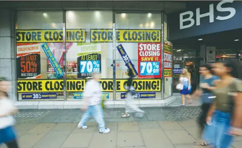  ?? (Neil Hall/Reuters) ?? PEDESTRIAN­S WALK past a BHS store in London yesterday. British Home Stores was sold with a £571 million hole in its pension fund, which if not filled will leave 20,000 pensioners facing significan­t cuts to their income.