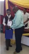  ??  ?? Shamier Riettels, the top achiever in Grade 10, is congratula­ted by principal Timotheus Webb.