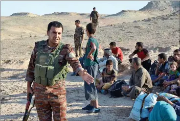  ??  ?? GUARDIAN: A Peshmerga soldier protects refugees fleeing the region