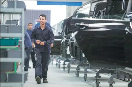  ?? XU ZIJIAN / XINHUA ?? Workers check auto parts at Geely’s plant in Montevideo, Uruguay.