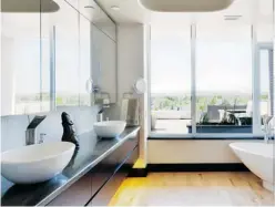  ??  ?? Above: Today’s upscale bathrooms often start with oversized showers and freestandi­ng tubs that are almost sculptural and often sit next to a bank of windows, like this awardwinni­ng one in a Westboro condo.