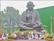  ?? PTI ?? Suspended MPs of Rajya Sabha sit on dharna near Mahatma Gandhi statue in Parliament complex on Wednesday.