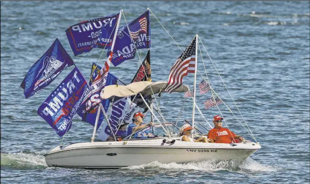 ?? L.E. Baskow Las Vegas Review-Journal @Left_Eye_Images ?? A boat decked out with flags of support for President Donald Trump takes part in the parade Saturday on Lake Mead.