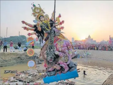  ?? HT PHOTO ?? ■ Idol immersion in an artificial pond in Jhulelal Vatika. This year all the Durga Puja committees agreed to immerse their idols in pits created at various places by the district administra­tion.