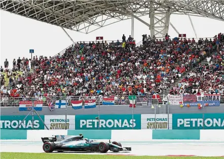  ??  ?? Out in full force: Mercedes-Petronas driver Valtteri Bottas driving past the huge crowd that turned up for the qualifying session at the Sepang Internatio­nal Circuit.