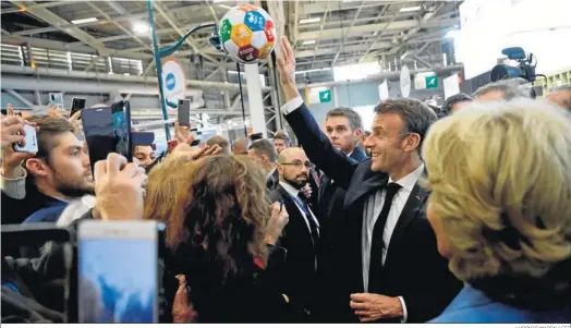  ?? LUDOVIC MARIN / EFE ?? Emmanuel Macron devuelve un balón tras firmarlo durante la 104ª sesión del Congreso de Alcaldes celebrado en París.