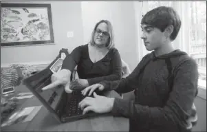  ?? The Associated Press ?? HEALTH COVERAGE: Jodi Smith Lemacks, left, works with her son, Joshua, on Oct. 16 in their home in Richmond, Va. Lemacks is nervous about changing or losing her job because that could mean cutting off her son Joshua from heart specialist­s he’s seen his entire life.