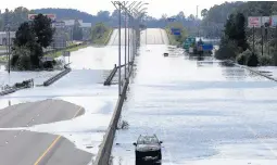  ?? GERRY BROOME/AP ?? Flooded vehicles sit on a closed section of I-95 in Lumberton, N.C., earlier this week.