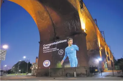  ??  ?? ●●City star Phil Foden’s picture projected onto Stockport viaduct in his home town